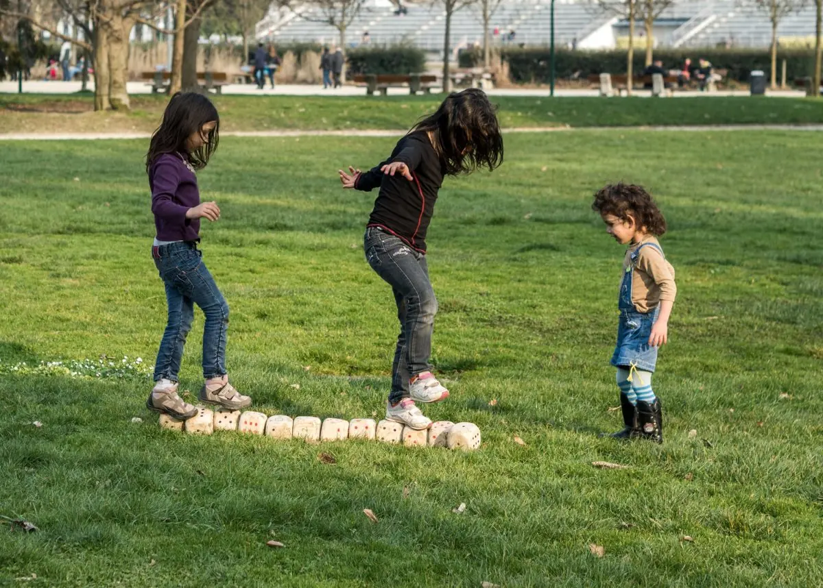 Trois enfants lancent des Caboules sur une pelouse